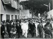 Fotografia de Américo Tomás, acompanhado por António Augusto Peixoto Correia, caminhando em cortejo pelas ruas de Ilha do Príncipe, por ocasião da visita oficial efetuada a São Tomé e Príncipe