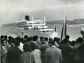 Fotografia da população despedindo-se de Américo Tomás durante a partida para a visita de estado a Moçambique a bordo do iate Príncipe Perfeito, na Gare Marítima de Alcântara, em Lisboa.