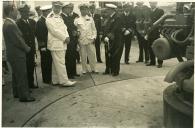 Fotografia de Américo Tomás assistindo à demonstração do funcionamento dos equipamentos da Escola da Direção de Tiro do Centro de Instrução Almirante Wandenkolk (C.I.A.W.)