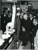 Fotografia de Américo Tomás, acompanhado por José João Gonçalves de Proença, visitando uma exposição do Congresso Nacional da Prevenção de Acidentes de Trabalho