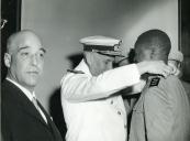 Fotografia de Américo Tomás, acompanhado por António Augusto Peixoto Correia, condecorando um soldado em Lourenço Marques, por ocasião da visita de estado efetuada a Moçambique