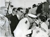 Fotografia de Américo Tomás cumprimentando uma criança, por ocasião da visita oficial efetuada ao Algarve, de 10 a 14 de julho de 1965