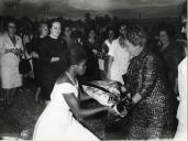 Fotografia de Gertrudes Rodrigues Tomás em Quelimane, recebendo um ramo de flores por ocasião da visita de estado efetuada por Américo Tomás a Moçambique