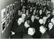 Fotografia de Américo Tomás, acompanhado por César Moreira Batista nas instalações do S.N.I., presidindo à inauguração de uma exposição de fotografias promovida pela Liga dos Combatentes da Grande Guerra