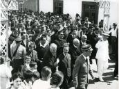 Fotografia de Américo Tomás, acompanhado por Alfredo Rodrigues dos Santos Júnior, saudando a população por ocasião da visita efetuada por ocasião da visita efetuada ao distrito de Bragança, de 29 a 31 de agosto de 1964