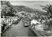 Fotografia de Américo Tomás circulando em cortejo automóvel no Funchal, onde inaugura o Aeroporto de Santa Catarina, por ocasião da visita de estado efetuada a Moçambique