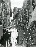 Fotografia de Américo Tomás, acompanhado por Alfredo Rodrigues dos Santos Júnior, saudando a população durante o cortejo a pé, por ocasião da visita efetuada ao distrito do Porto, de 17 a 22 de junho de 1964